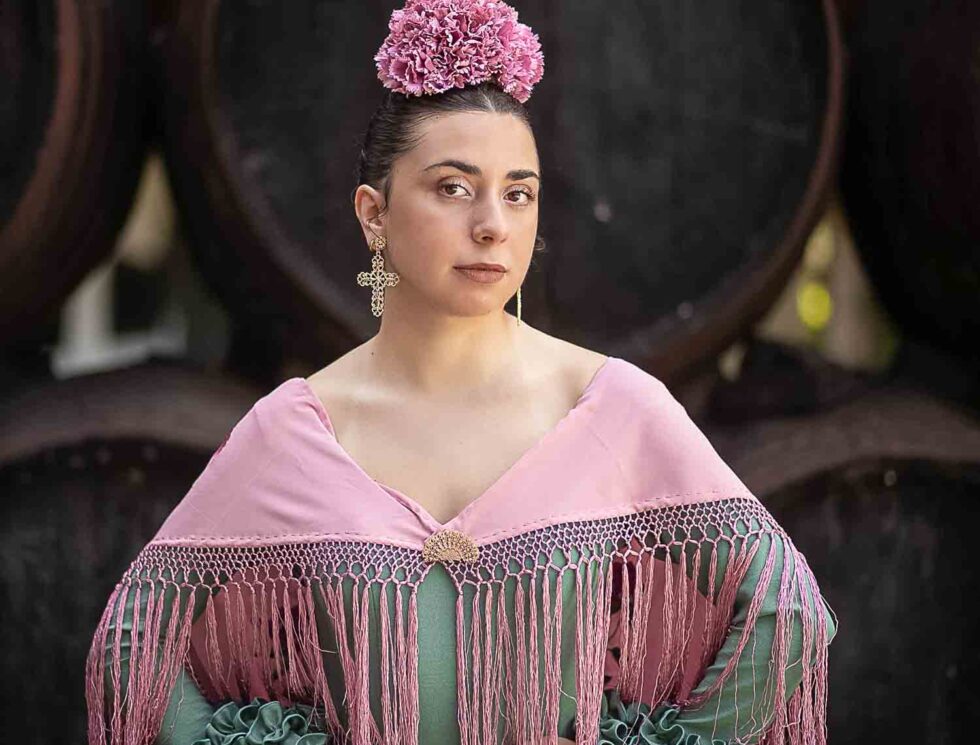 Mujer vestida de gitana durante la feria de Chiclana posando en una bodega