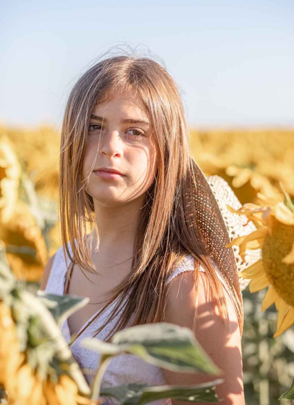 Joven posando entre girasoles