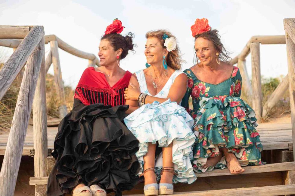 Tres mujeres vestidas de gitana durante la feria de Chiclana posando en un entorno natural