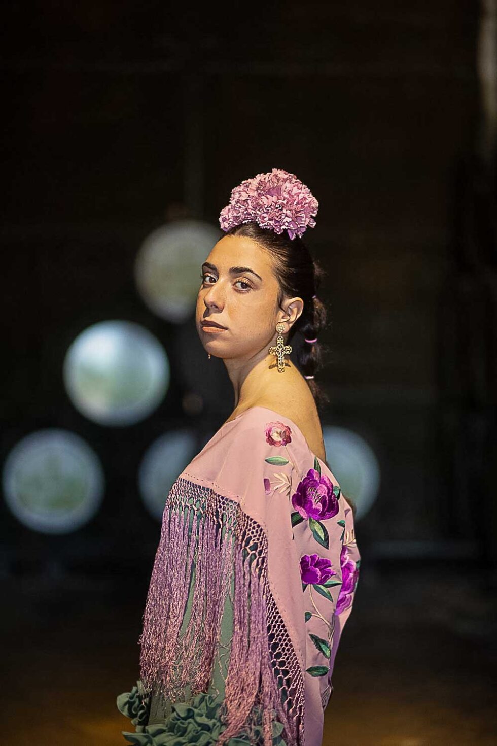 Mujer vestida de flamenca mirando a cámara