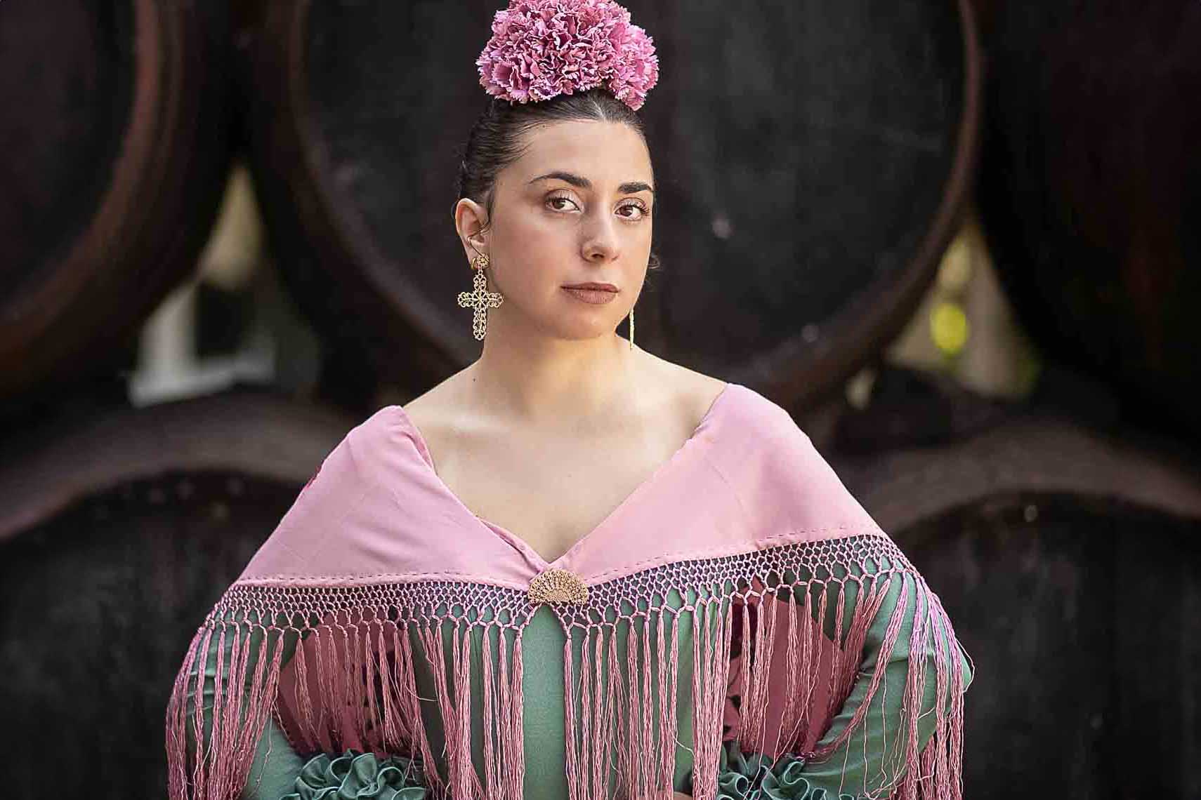 Mujer vestida de feria posando en una bodega